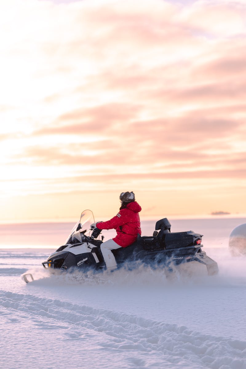 Turistas conduciendo motos de nieve entre paisajes nevados de Rovaniemi