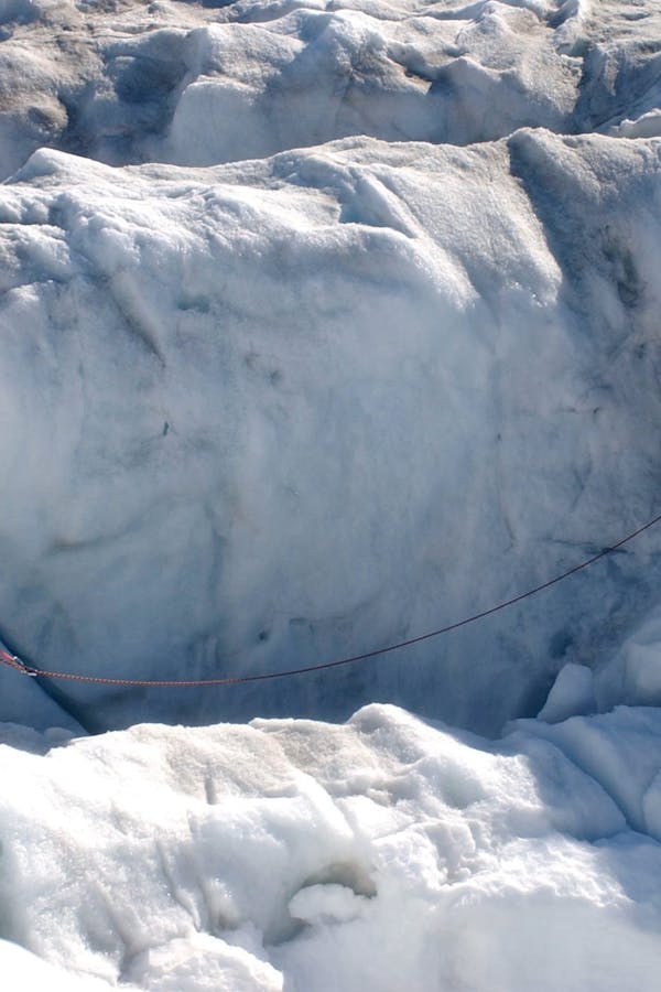 Detalle de crampones sobre hielo azul