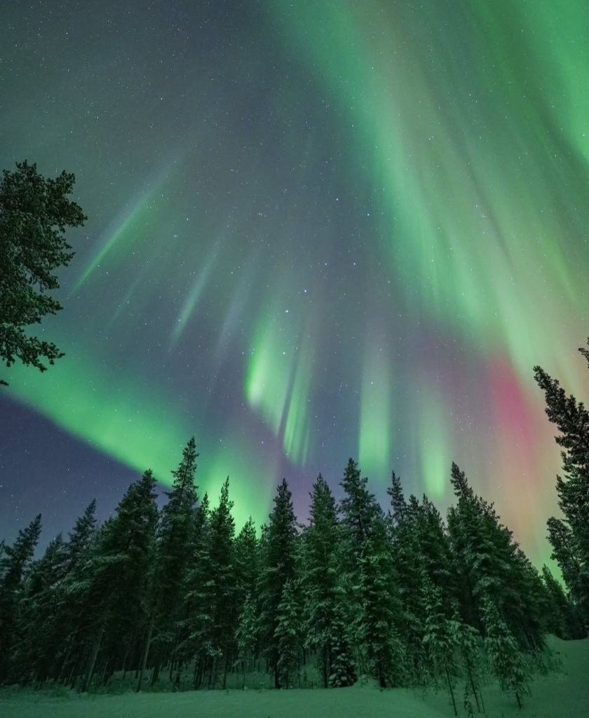 Cielo nocturno en Rovaniemi con aurora boreal, ambiente ártico y nieve
