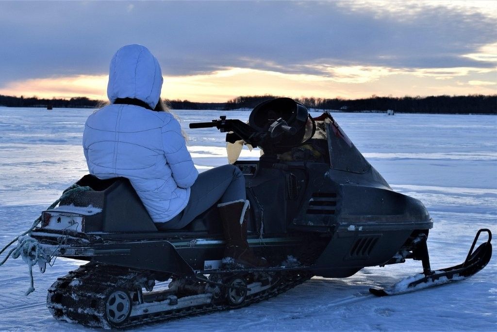 Turistas aprendiendo a conducir motos de nieve con guía en Rovaniemi